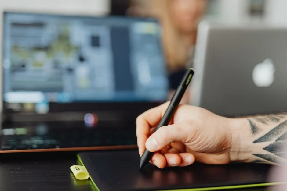 A close-up of a modern workspace, featuring a laptop and smartphone in use.